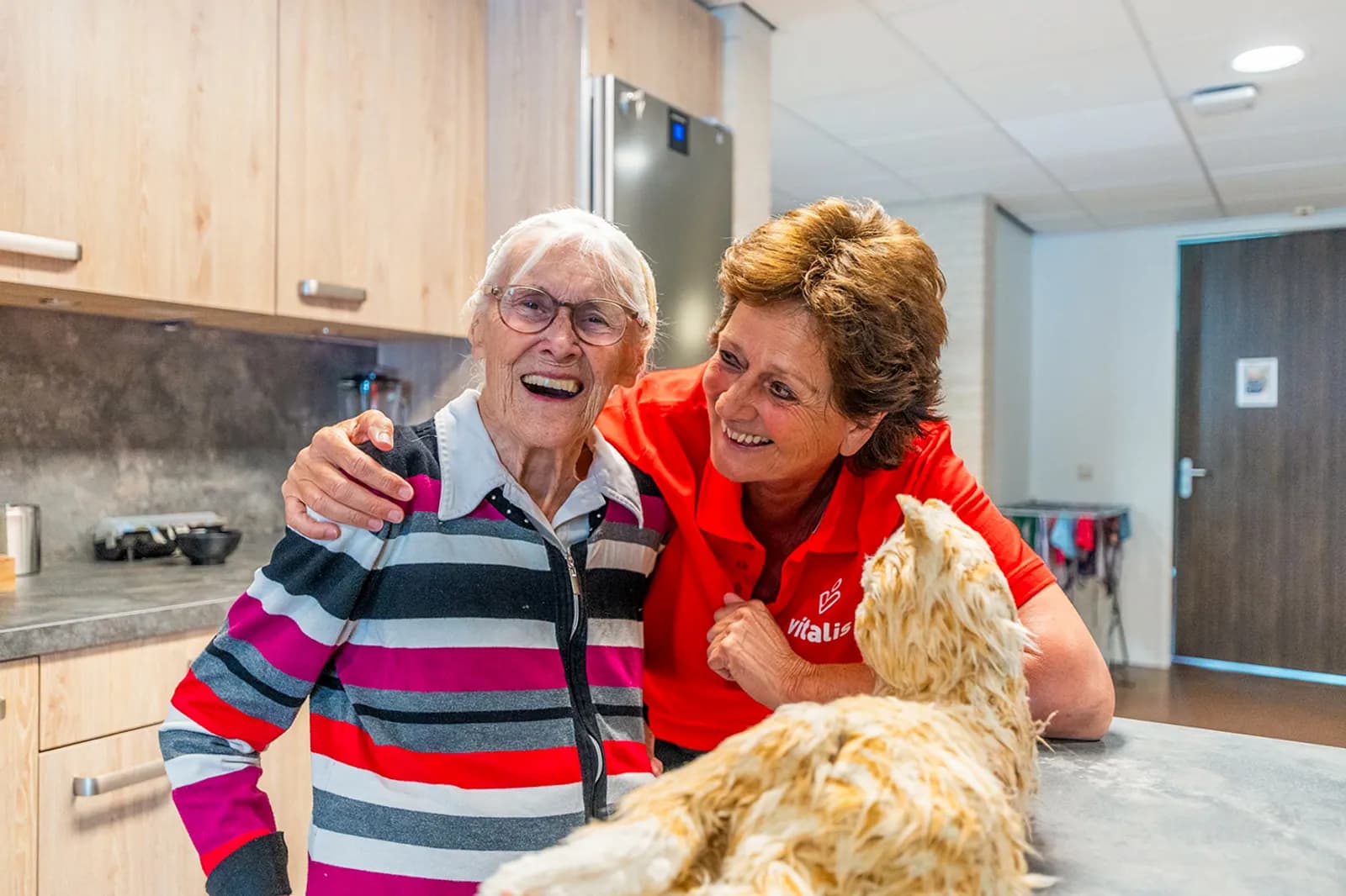 een zorgmedewerker en een oudere met een zorgrobotkat