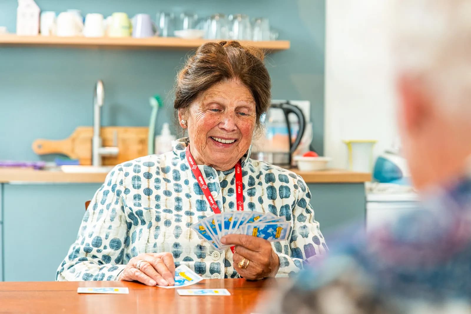 Vier ouderen aan tafel die rummikub aan het spelen zijn