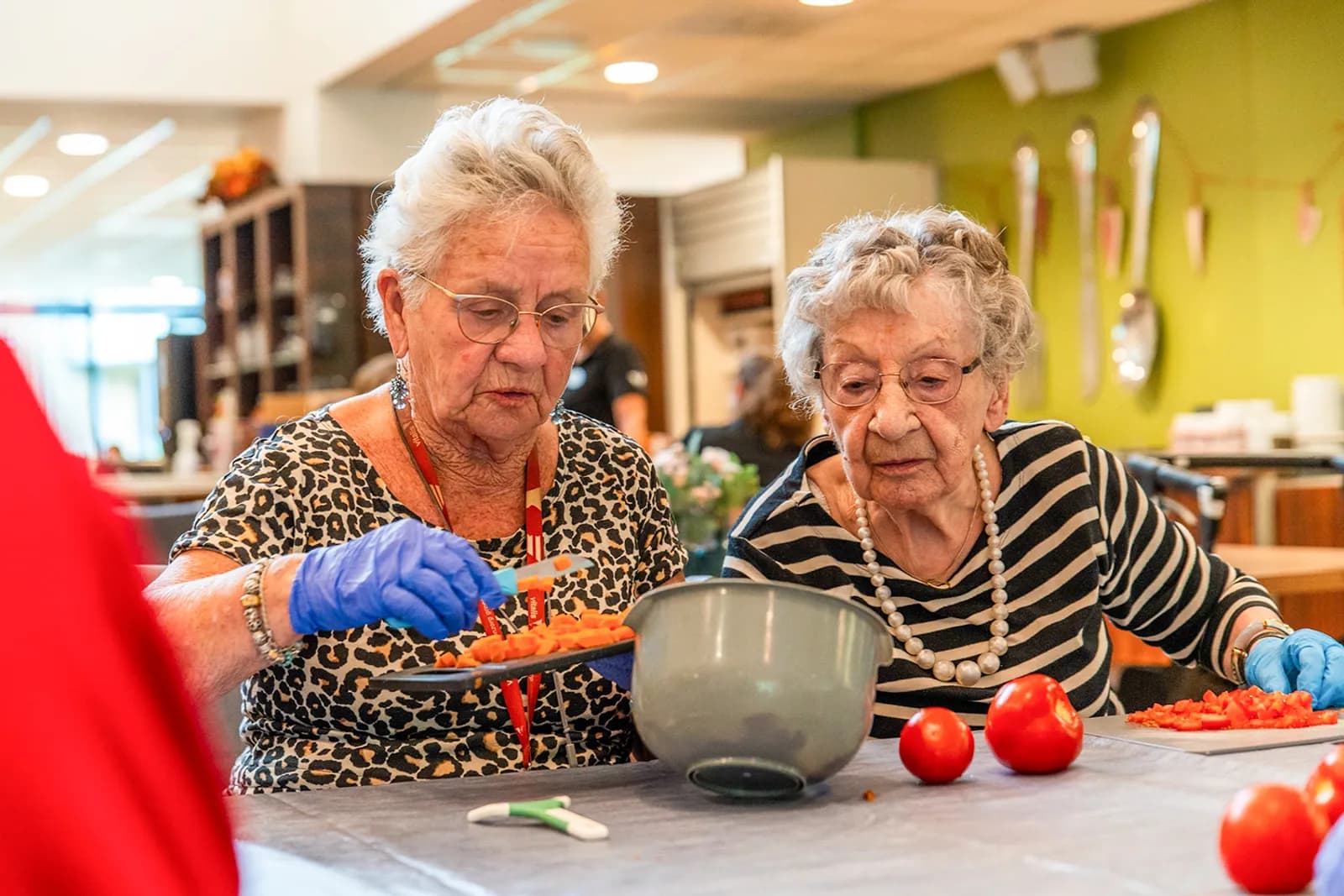 drie ouderen en een medewerker zijn aan het koken