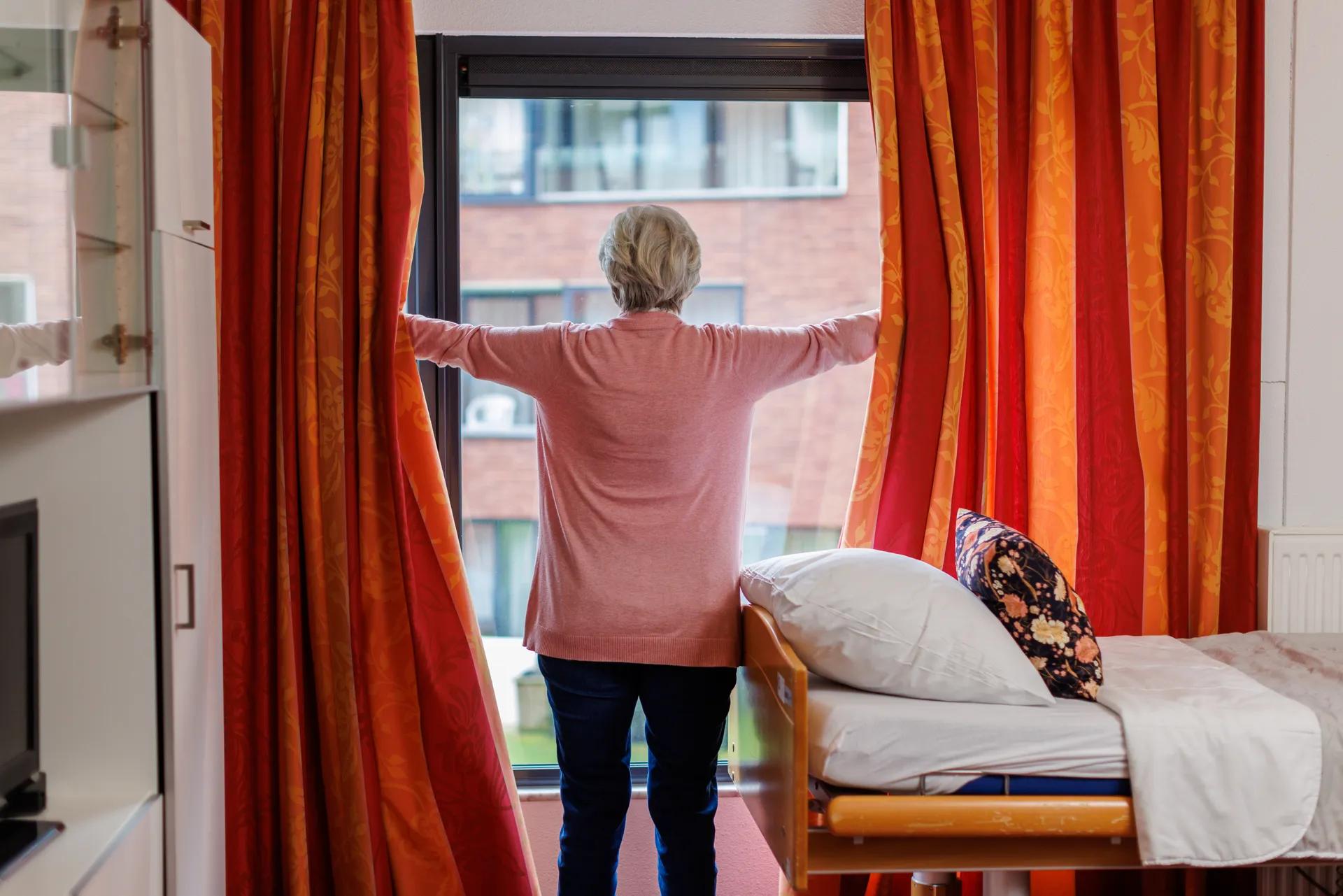Mevrouw opent gordijnen