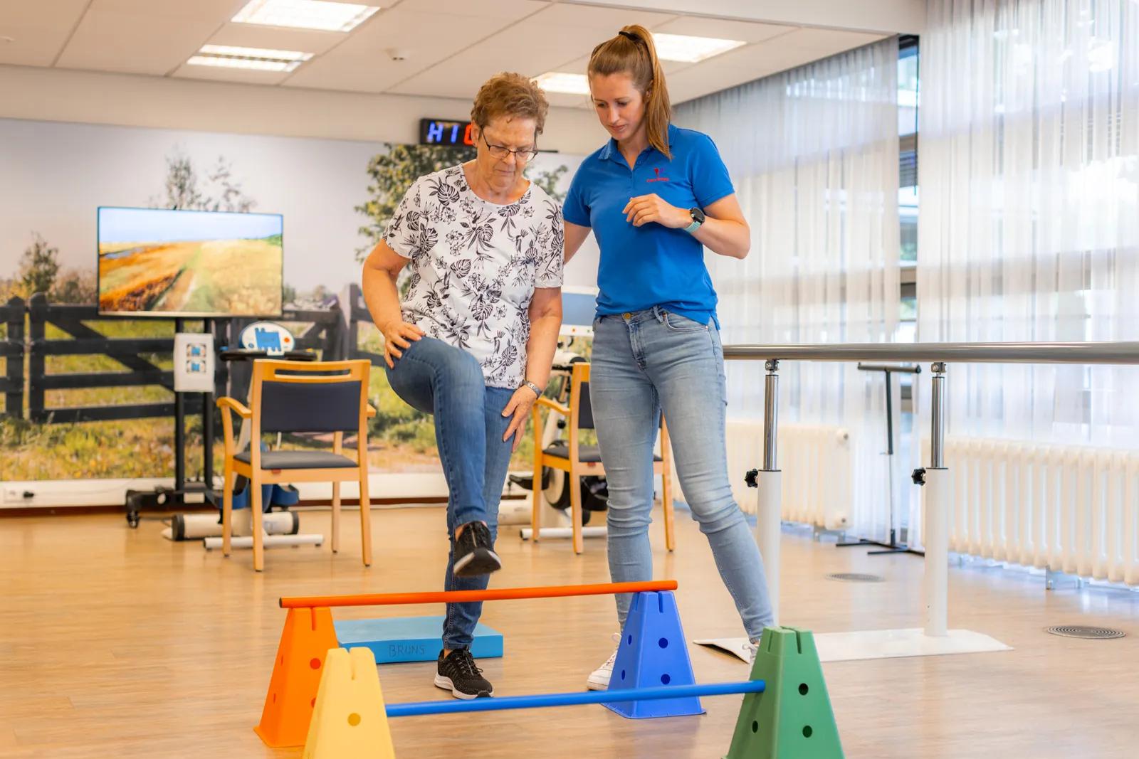 Een fysiotherapeute en een oudere tijdens een behandeling