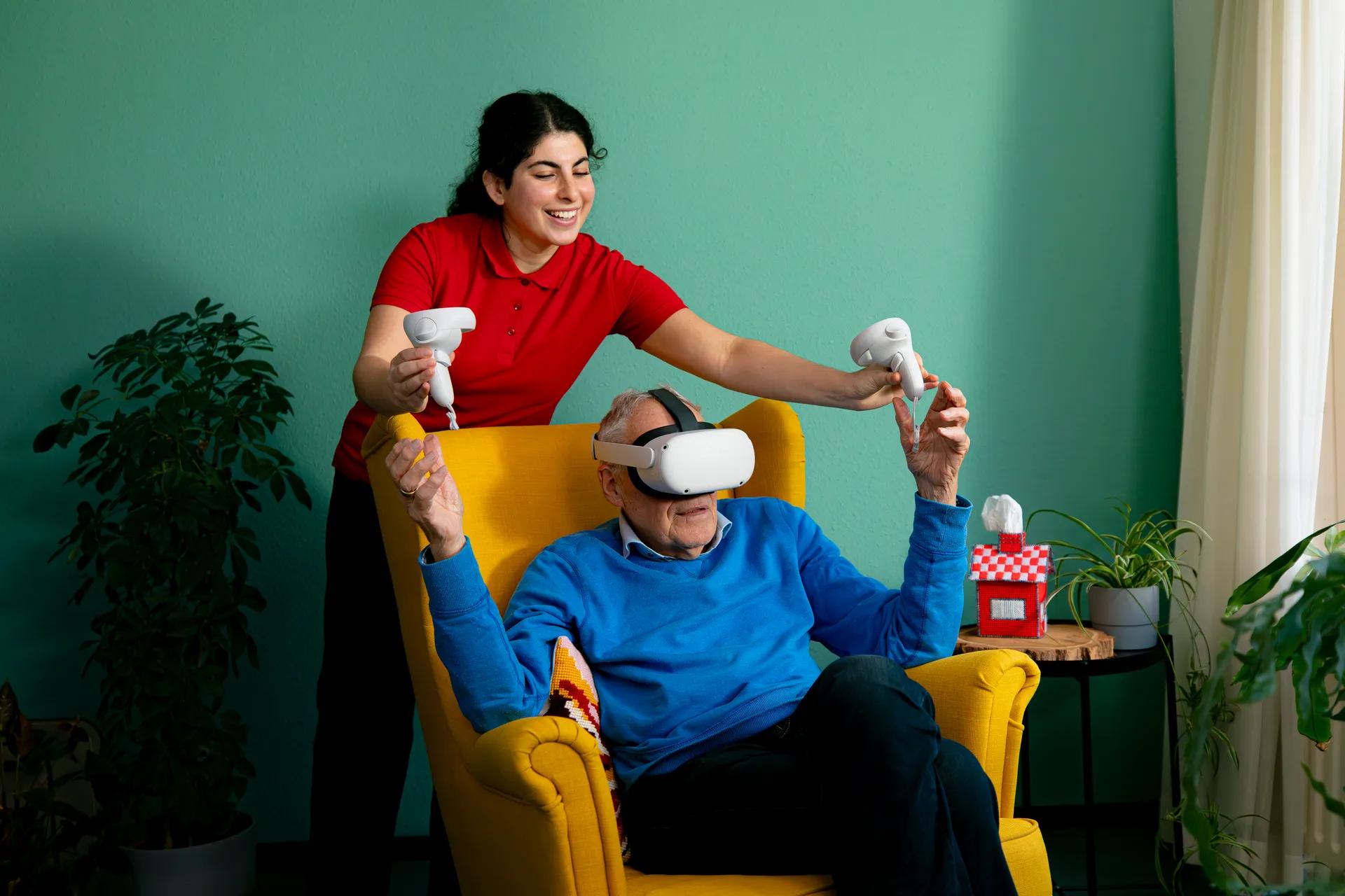 Een oudere en een medewerker met een VR bril