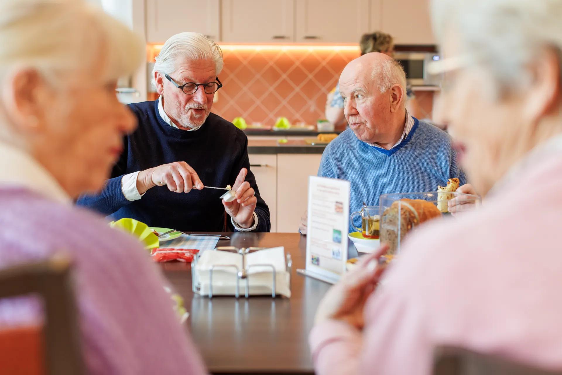 vier ouderen aan tafel aan het eten