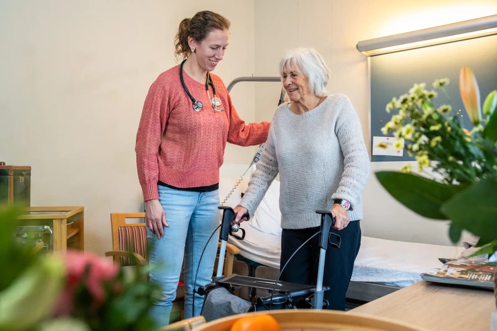 Arts helpt mevrouw met rollator